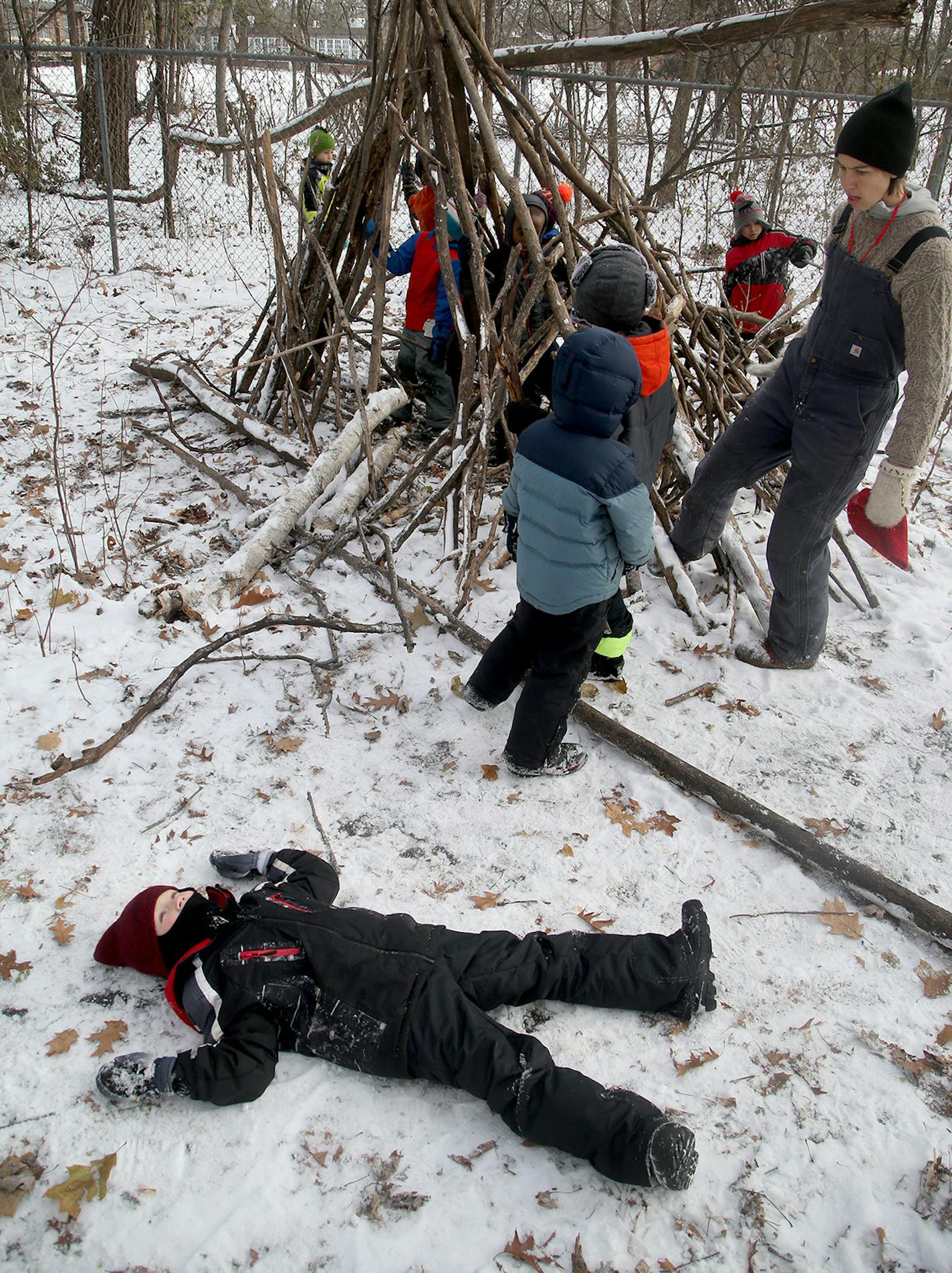 Free Forest School executive director Anna Sharratt, right, has brought Free Forest School to Dowling Environmental Elementary School. Once a week, a first-grade class sets out for an hour of free play. Several children minded their lean-to Dec. 8.