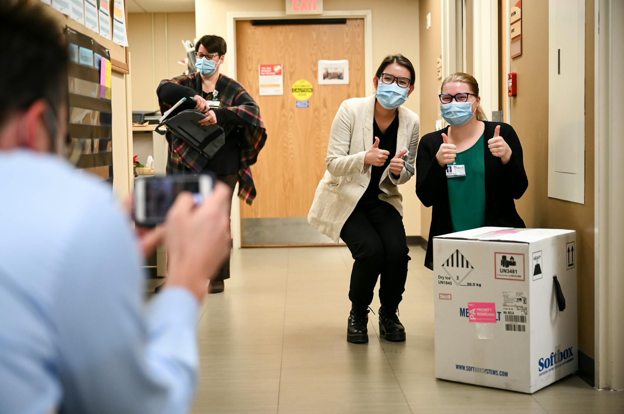 From right, Hayley Kytta and Tam Nguyen, both 4th year pharmacy students at the University of Minnesota, posed for a photo with a box containing 975 doses of the Pfizer COVID-19 vaccine which just arrived at North Memorial Health Hospital Tuesday morning.