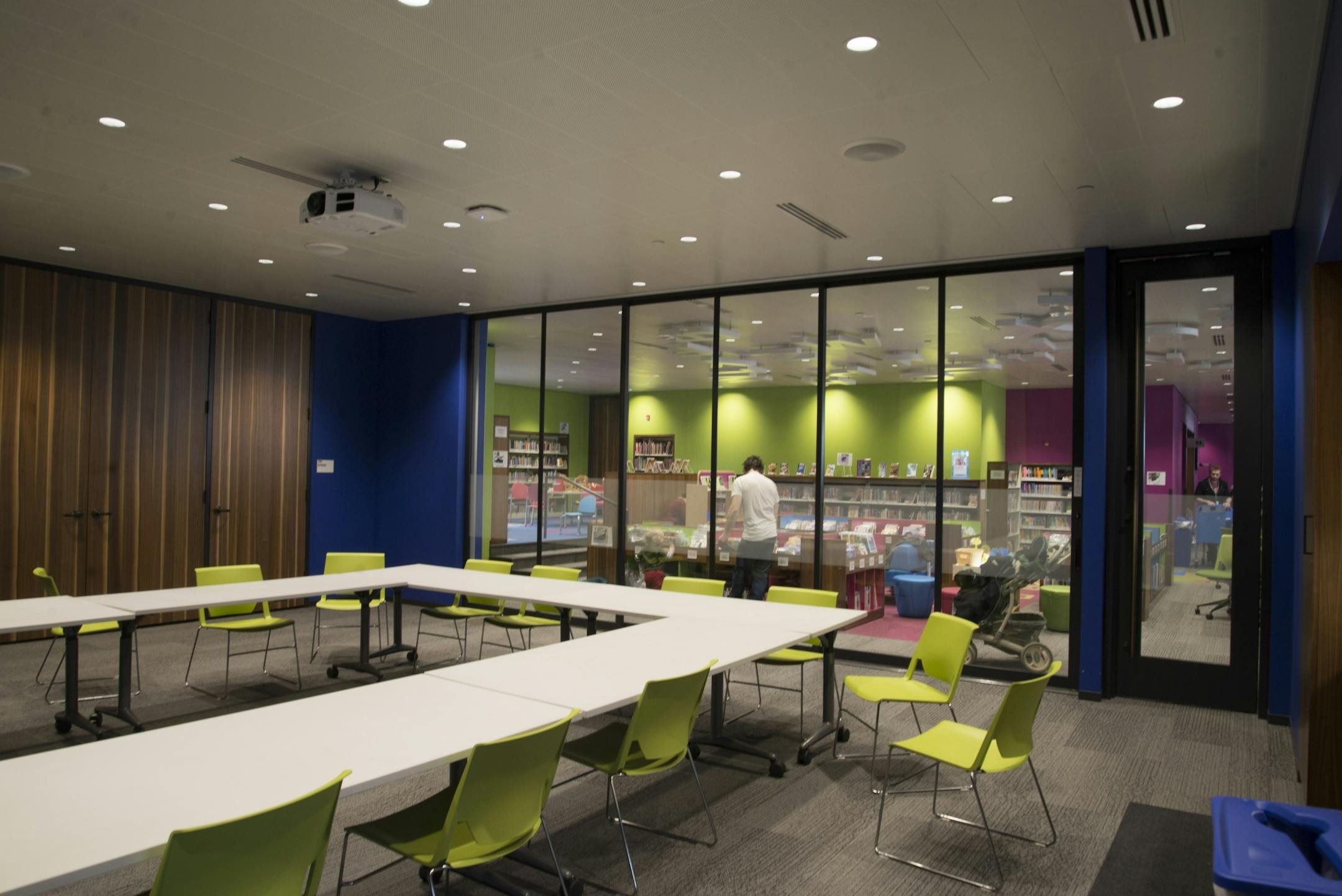 A conference room is bordered by a a children's reading area inside the Walker Library.