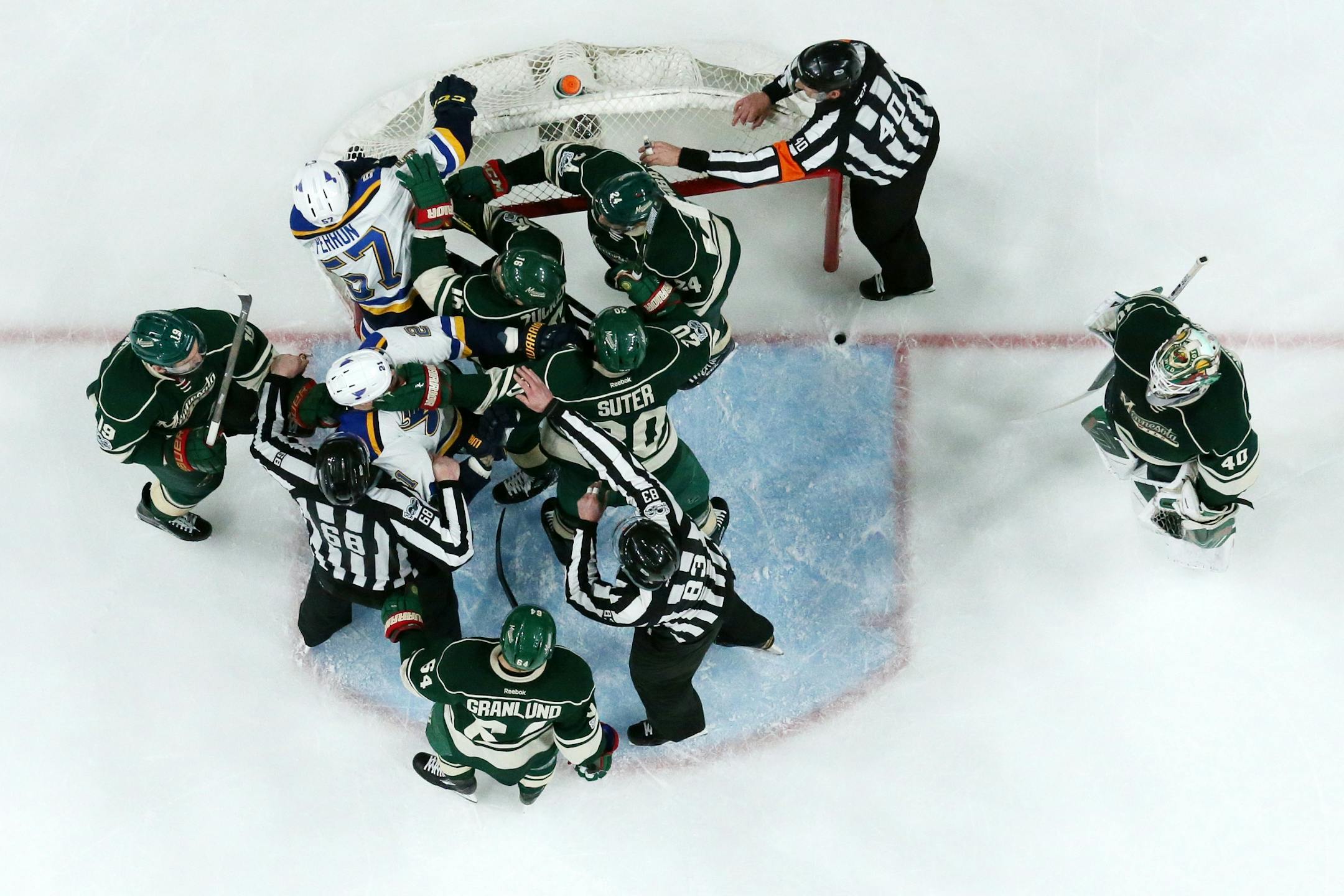 Game officials tried to break up a fight as Minnesota Wild goalie Devan Dubnyk (40) stood by in the first period.