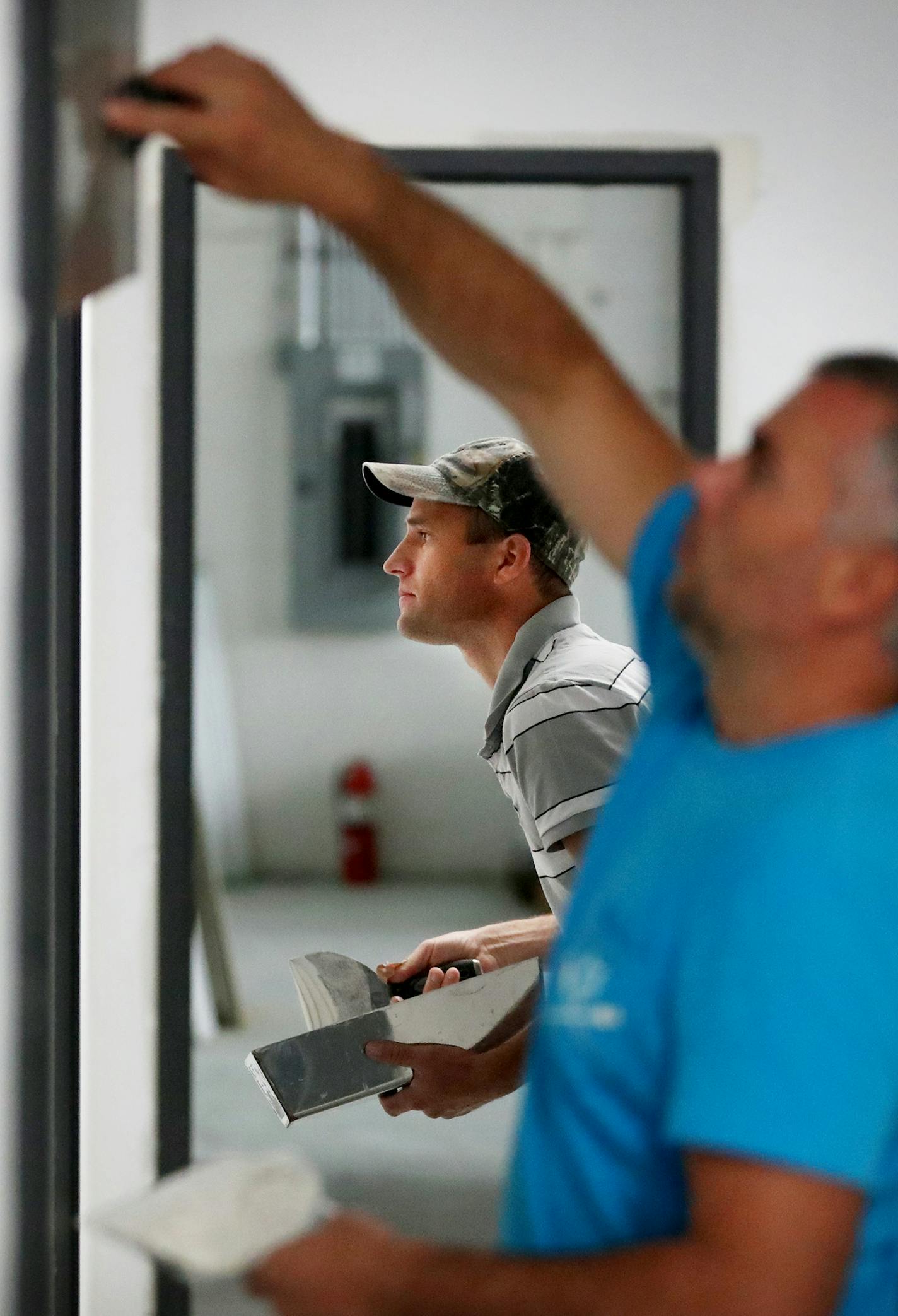 Vasiliy Chobanu, rear, and Andrey Gubceai, construction/remodeling workers for Mastertile, who subcontracted work for Summit Commercial Facilities Group, trowel joint compound onto sheet rocked walls on Summit's office remodel for Adhesive Systems Technology Thursday, June 29, 2017, in Brooklyn Center, MN. ] DAVID JOLES &#x2022; david.joles@startribune.com Nearly a year after the completion of the Vikings stadium, there is still a massive construction crunch with companies having a hard time fin