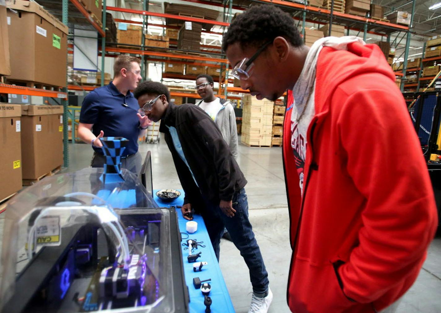 Graco played host to its first Manufacturing Day last fall to encourage hands-on jobs as a path to middle class. Among those participating were Patrick Henry High students, right to left, Devontaye Spates, Marquan Vance and Tyrell Dunlap, who were learning about 3-D printing from Graco&#x2019;s Chad Hockemeyer, left.