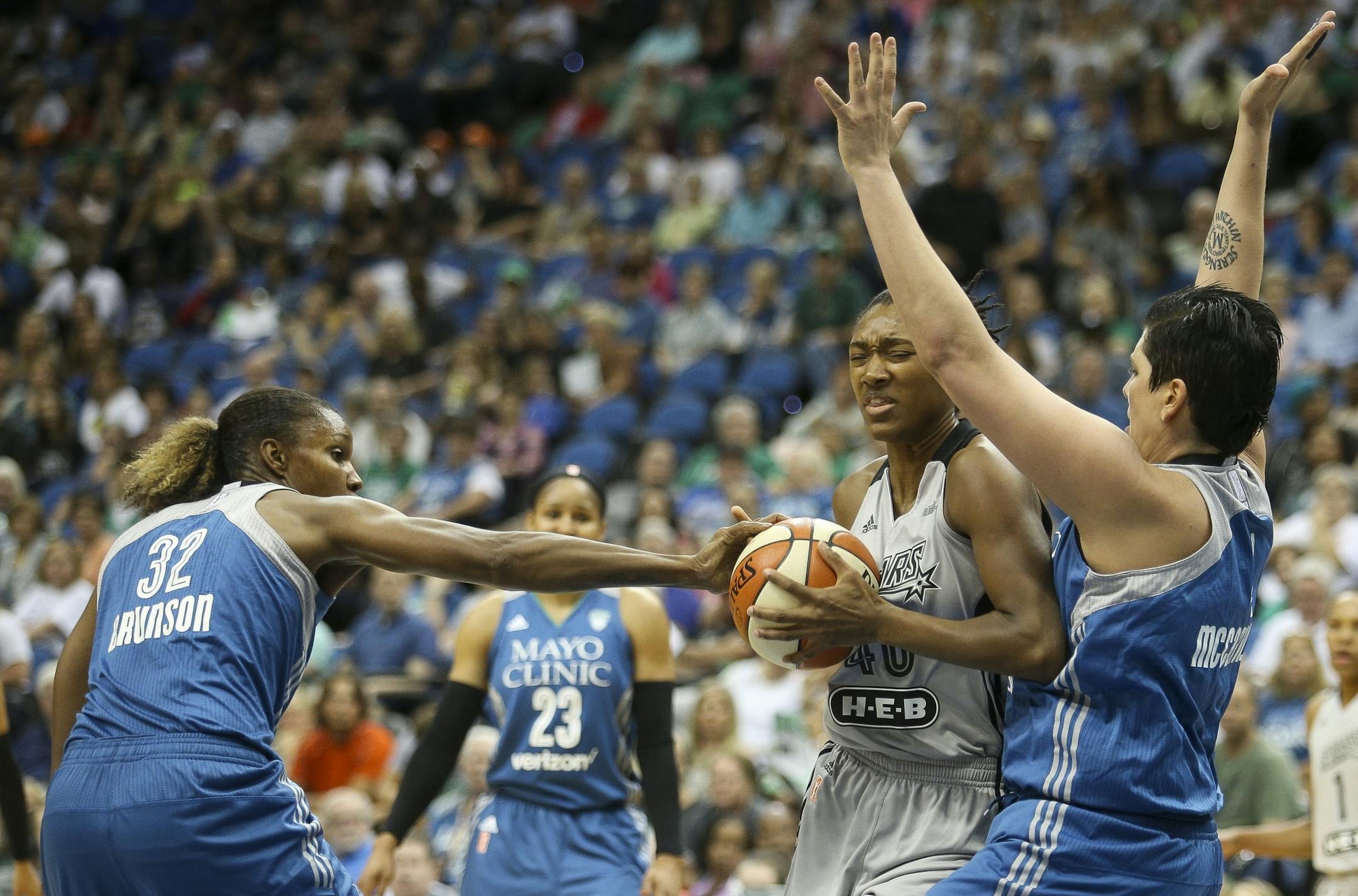 Minnesota Lynx forward Rebekkah Brunson (32) gets a hand on the ball to disrupt San Antonio Stars center Kayla Alexander (40) as she goes to the rim.