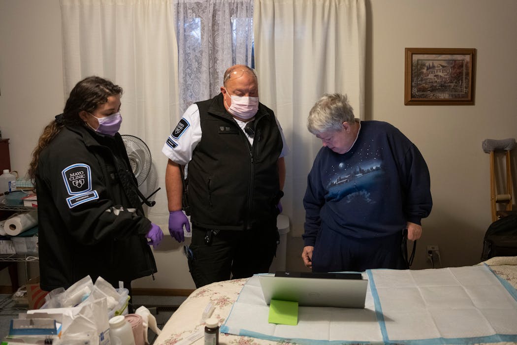 Community paramedics Phoebe Sanft and Brand Buch go through some details of Barb Virnig’s care before they rewrapped a wound on her upper leg on Tuesday in Rochester. Mayo Clinic is getting recognition for its community paramedic program that offers preventive care for patients at their home.