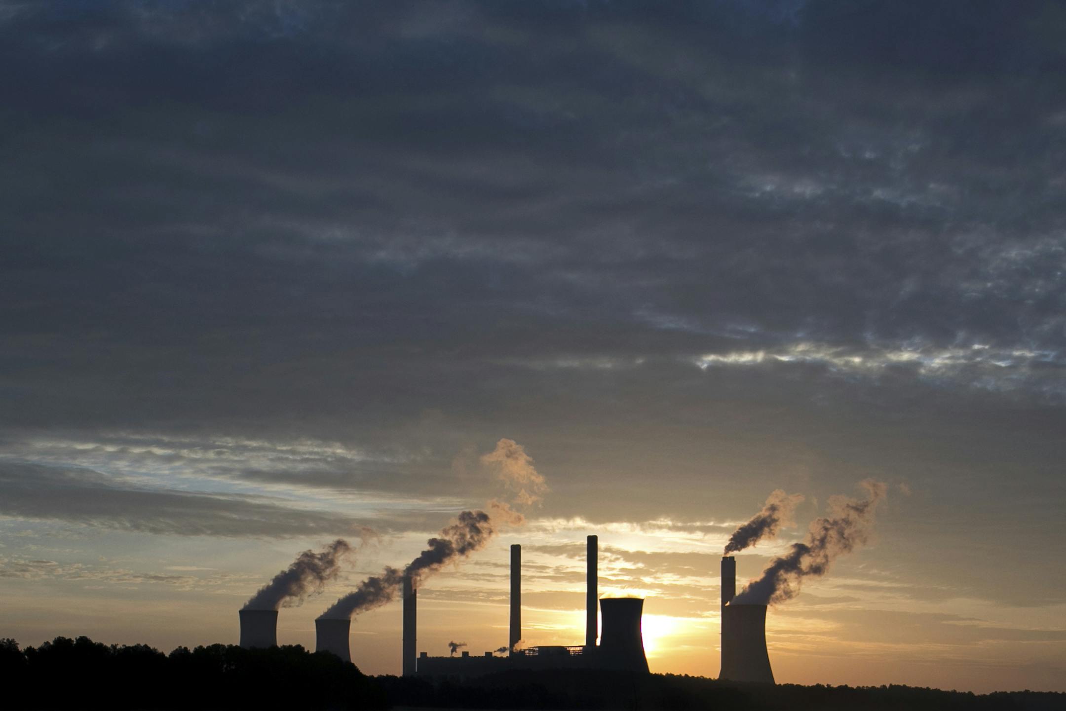 FILE - In this June 3, 2017, file photo, the coal-fired Plant Scherer, one of the nation's top carbon dioxide emitters, stands in the distance in Juliette, Ga. A new poll finds that less than a third of Americans support President Donald Trumpís decision to withdraw from the Paris climate accord, with just 18 percent of respondents agreeing with his claim that pulling out of the international agreement to reduce carbon emissions will help the U.S. economy.(AP Photo/Branden Camp, File)