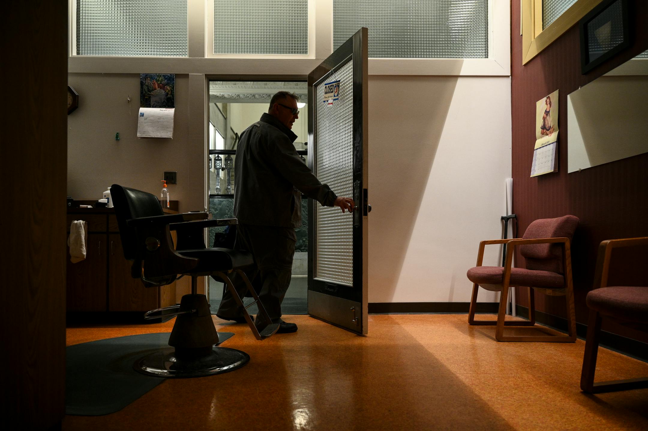 Bob Haddow, veteran barber and philosopher at the Grain Exchange Barbershop, turns off the lights and locks up for the night Wednesday. Haddow is out on Friday, thanks to remodeling of the 120-year-old building lobby by the Grain Exchange owner.