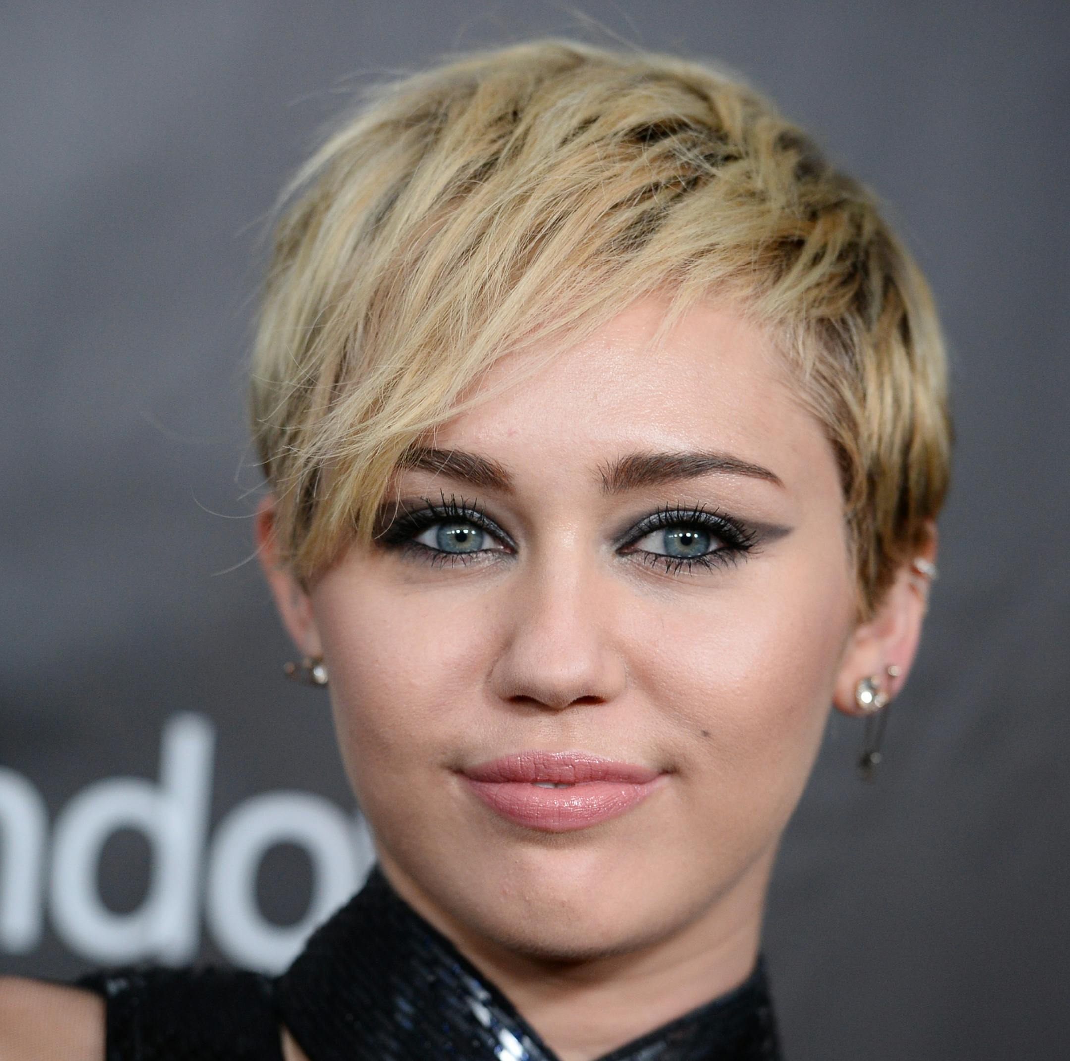 FILE - In this Oct. 29, 2014 file photo, Miley Cyrus arrives at the 2014 amfAR Inspiration Gala at Milk Studios in Los Angeles. A convicted burglar charged with breaking into the Los Angeles home of Cyrus has pleaded not guilty to felony charges. Rusty Sellner entered pleas Thursday, Jan. 8, 2015, to burglary, receiving stolen property and grand theft. He could face seven years and eight months in prison if convicted. (Photo by Jordan Strauss/Invision/AP, File) ORG XMIT: MIN2015020418290462