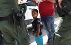 MISSION, TX - JUNE 12: A boy and father from Honduras are taken into custody by U.S. Border Patrol agents near the U.S.-Mexico Border on June 12, 2018