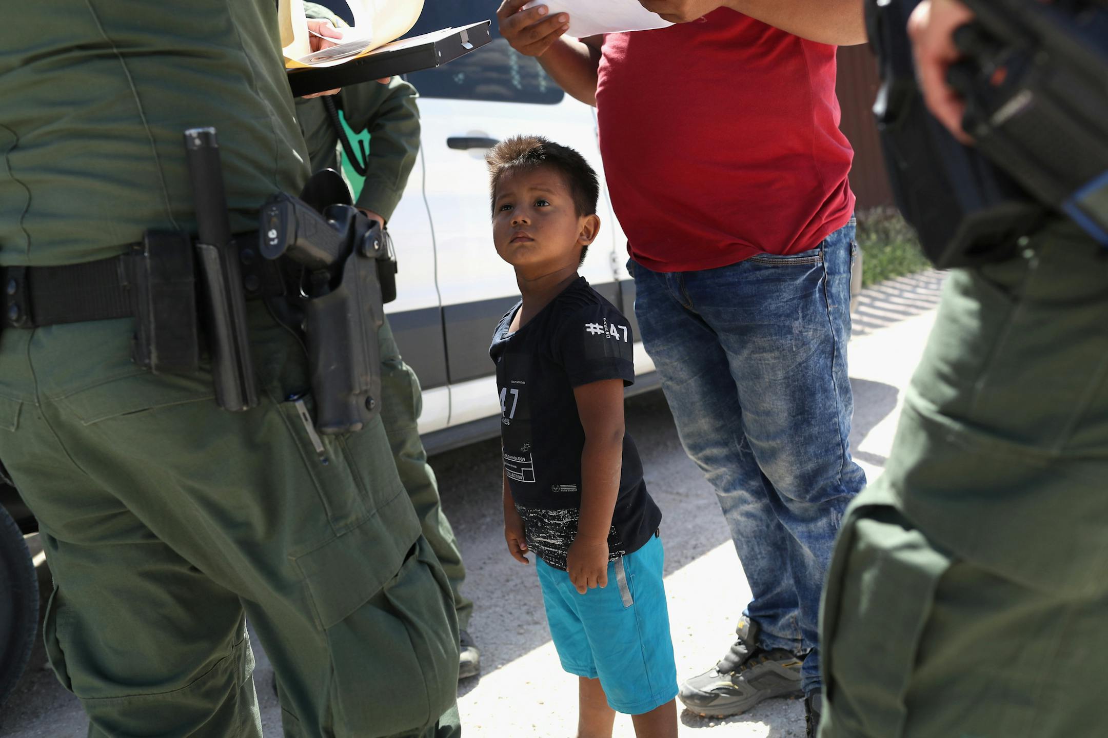 MISSION, TX - JUNE 12: A boy and father from Honduras are taken into custody by U.S. Border Patrol agents near the U.S.-Mexico Border on June 12, 2018 near Mission, Texas. The asylum seekers were then sent to a U.S. Customs and Border Protection (CBP) processing center for possible separation. U.S. border authorities are executing the Trump administration's "zero tolerance" policy towards undocumented immigrants. U.S. Attorney General Jeff Sessions also said that domestic and gang violence in im