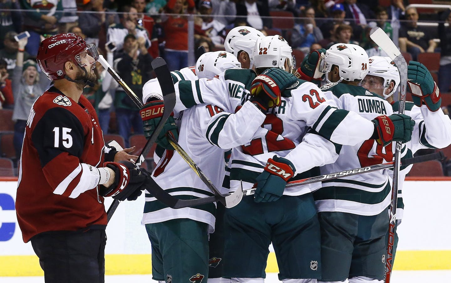 Minnesota Wild right wing Nino Niederreiter (22) celebrates his goal against the Arizona Coyotes with defenseman Matt Dumba (24), left wing Jason Zucker (16), and others as Coyotes center Brad Richardson (15) skates past during the first period of an NHL hockey game Saturday, March 17, 2018, in Glendale, Ariz. (AP Photo/Ross D. Franklin)