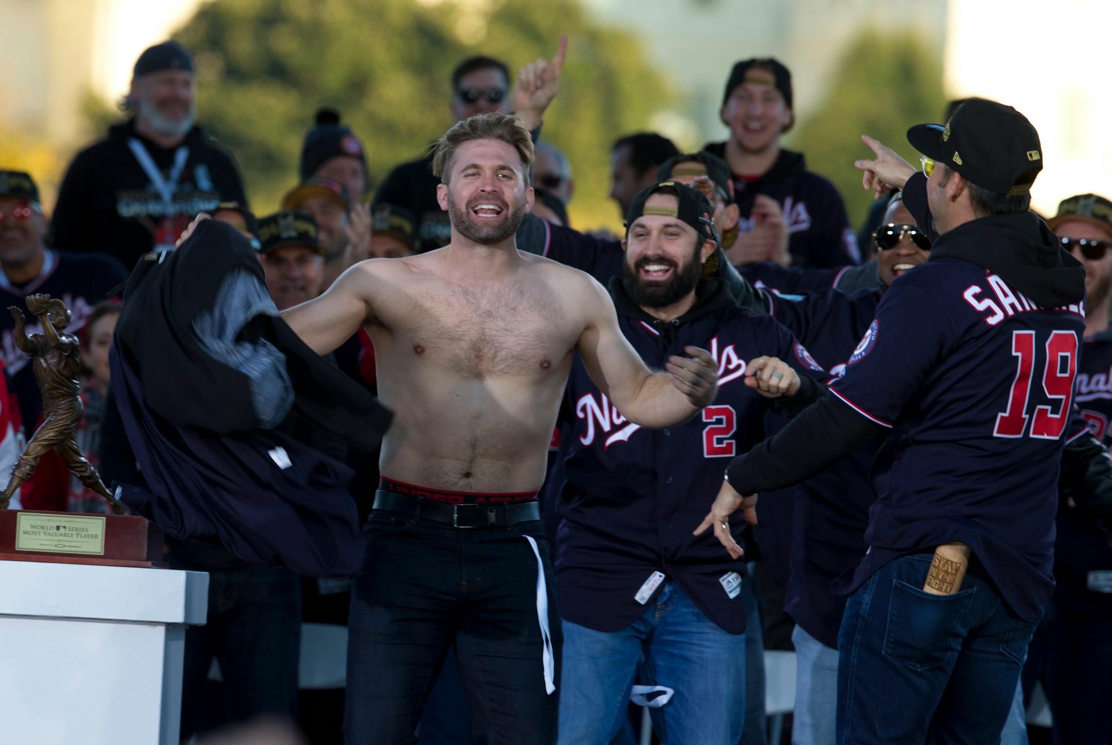 Washington Nationals second baseman Brian Dozier stands shirtless at a rally after a parade to celebrate the team's World Series baseball championship over the Houston Astros, Saturday, Nov. 2, 2019, in Washington. (AP Photo/Jose Luis Magana)