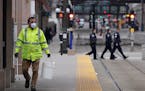 A worker wore a protective mask and gloves as he cleaned the light-rail platform outside Union Depot on Saturday in St. Paul.