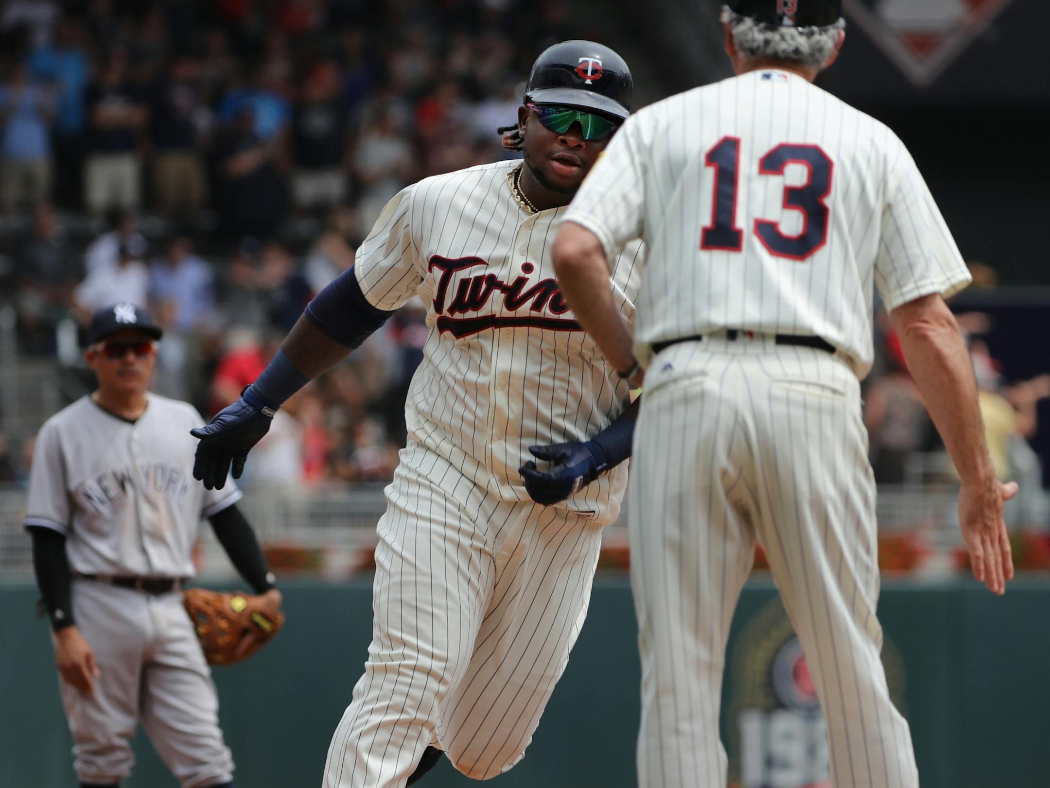 Miguel Sano(22) who just drove in Brian Dozier(2), right, and Eduardo Escobar(5) rounds third base in the second inning.