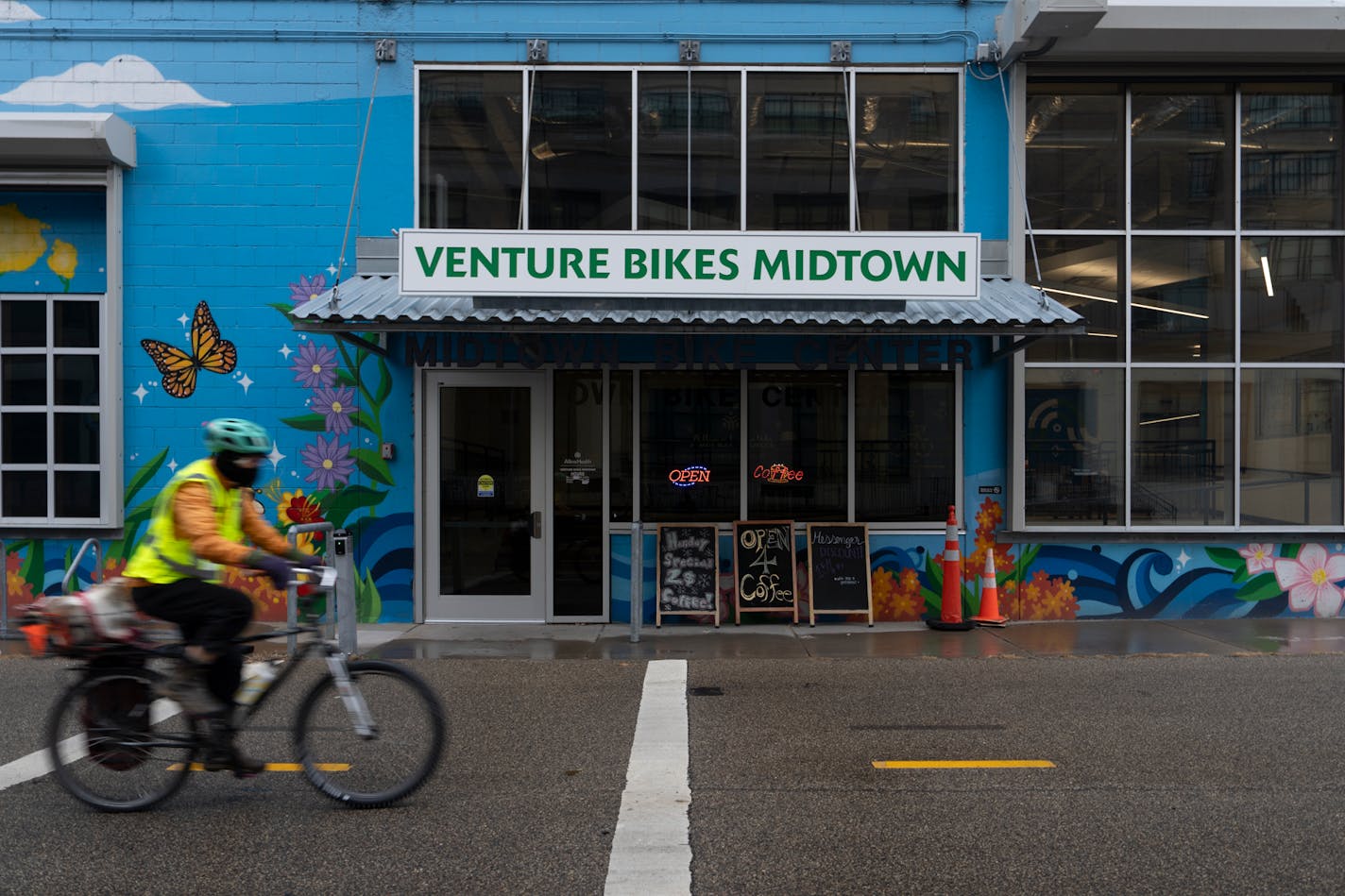 A commuter rides past the new home of Venture Bikes, in the space formerly occupied by Freewheel Bike Shop along the Midtown Greenway on Friday, December 22, 2023.