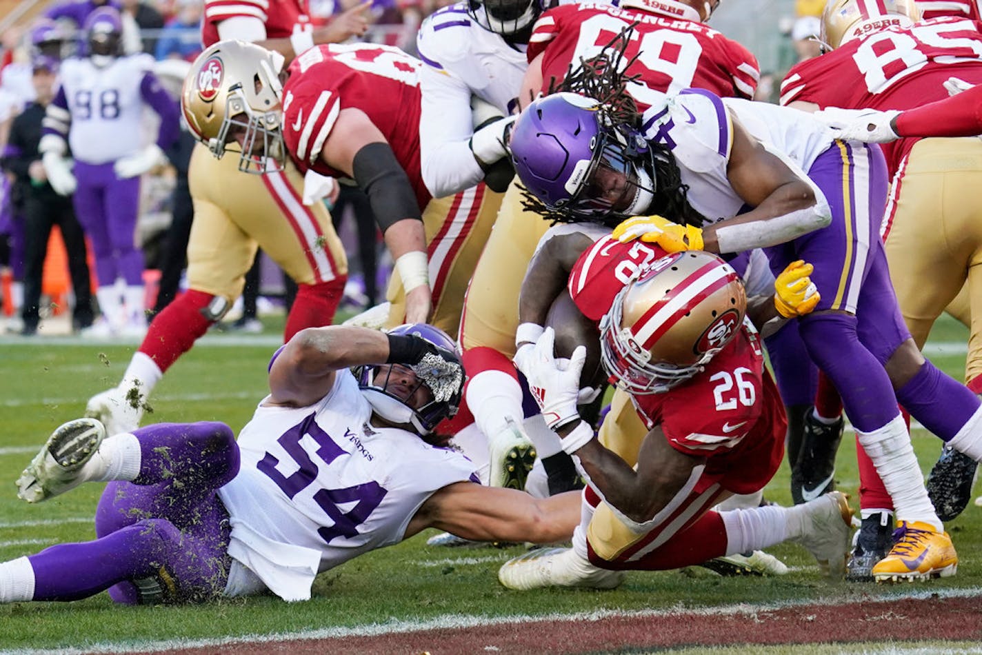 San Francisco 49ers running back Tevin Coleman (26) dives to score a touchdown between Minnesota Vikings middle linebacker Eric Kendricks (54) and defensive back Anthony Harris (41) during the second half.