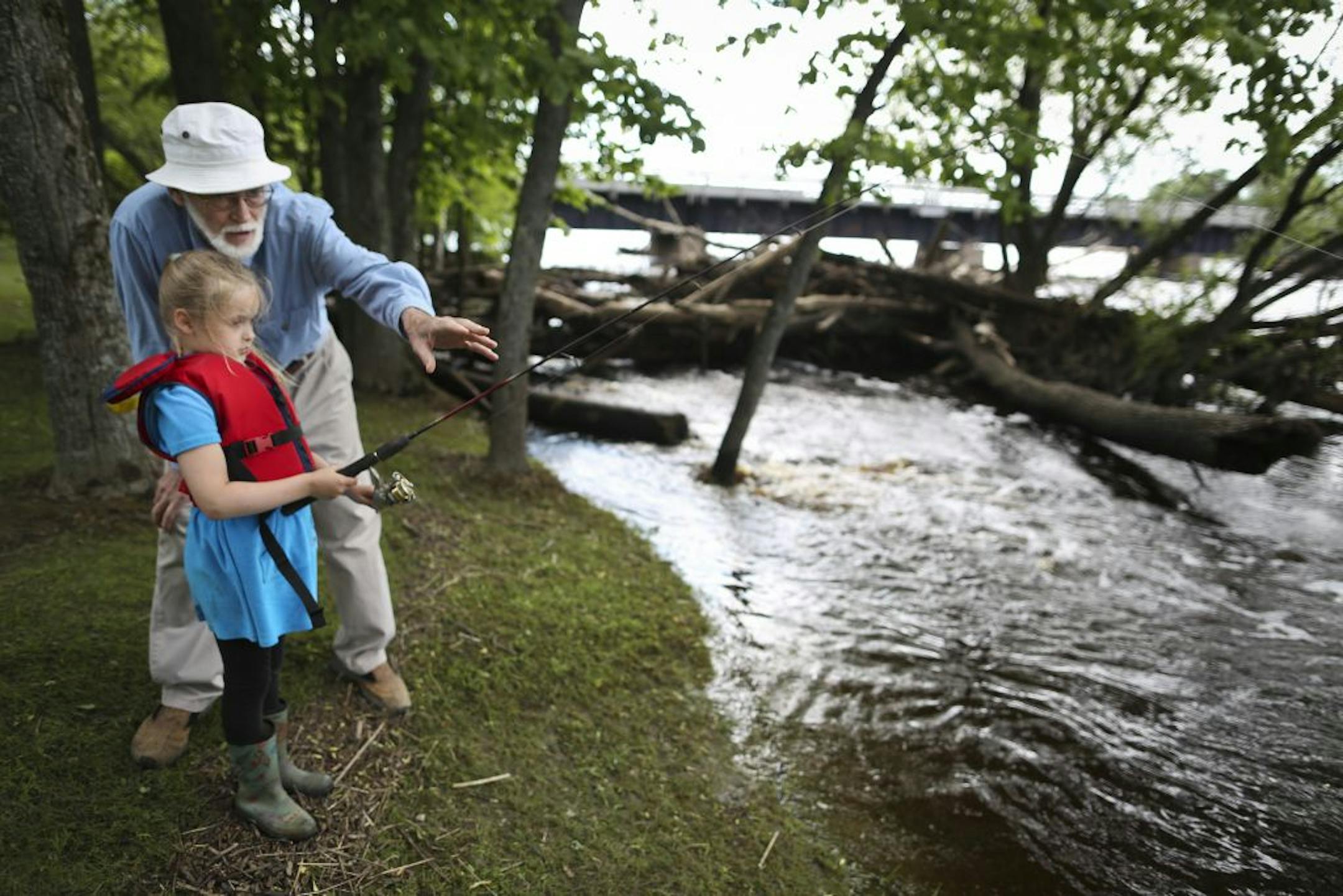Len Anderson gave his granddaughter Logan, 7, some tips as she tried fishing on the flooded St. Louis River on Tuesday, June 26, 2012 in Cloquet, Minn.