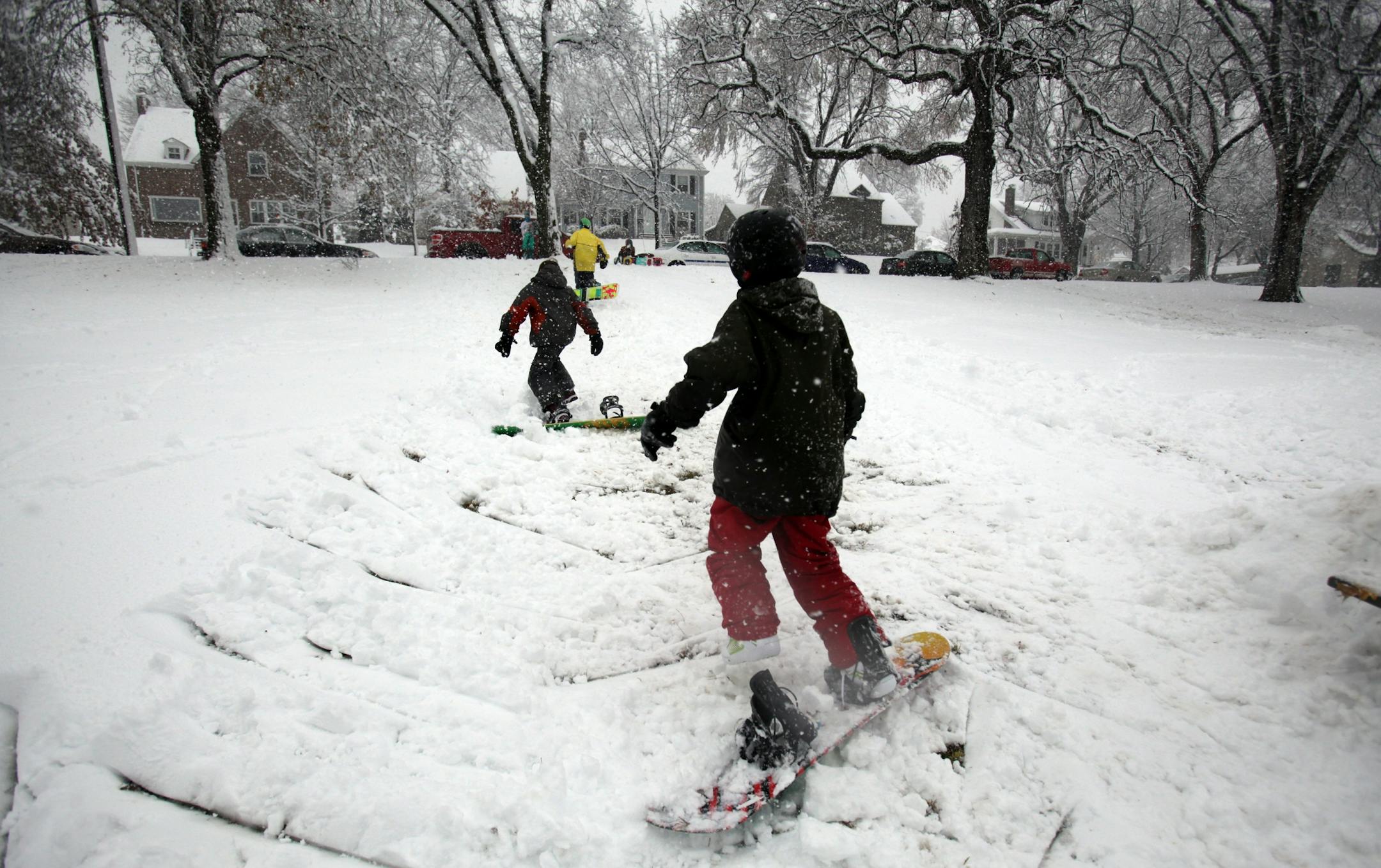 Daniel Connelly, 12, climbed back up the hill with his friends as they do snowboarding tricks in Pearl Park in South Minneapolis. The boys built a ramp out of snow that led up to the table where they performed their tricks.