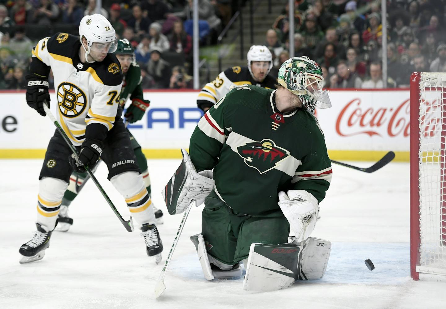 Minnesota Wild goaltender Devan Dubnyk (40) and Boston Bruins left wing Jake DeBrusk (74) watch as the shot by Boston Bruins' Torey Krug, not pictured, goes into the net during the second period of an NHL hockey game Saturday, Feb. 1, 2020, in St. Paul, Minn. (AP Photo/Hannah Foslien)