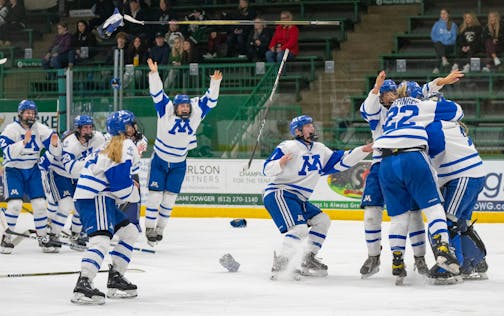 Minnetonka players rush goaltender Layla Hemp (1) after the final buzzer sounded. Minnetonka defeated Holy Family 4-0.