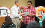 Gary Red Owl, right, a decedent of Santee Chief Cut Nose, receives an apology letter from Jeff Bolton, the Vice President and Chief Administrative Off