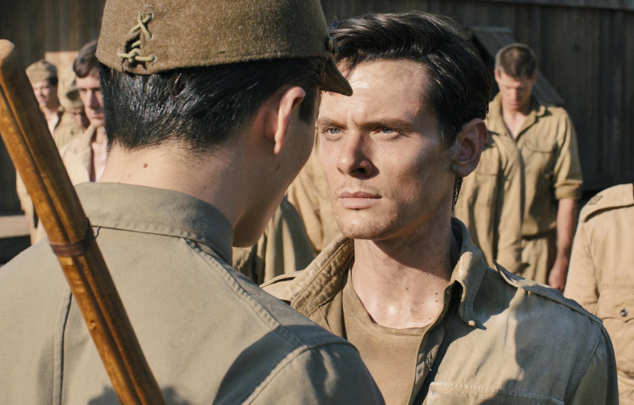 (L to R, foreground) The Bird (MIYAVI) torments Louis Zamperini (JACK O'CONNELL) in "Unbroken", an epic drama that follows the incredible life of Olympian and war hero Zamperini who, along with two other crewmen, survived in a raft for 47 days after a near-fatal plane crash in WWII‚Äîonly to be caught by the Japanese Navy and sent to a prisoner-of-war camp.