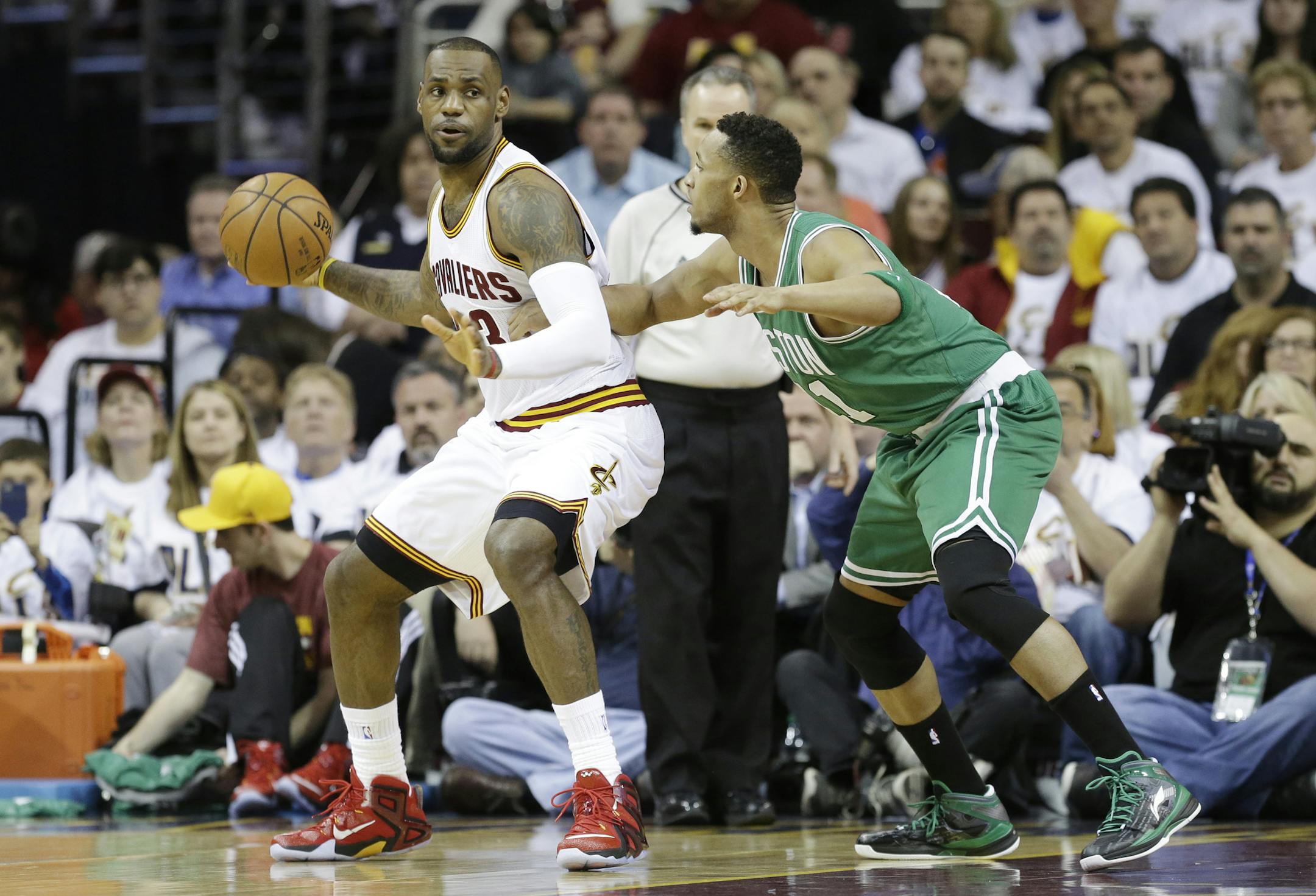 Cleveland Cavaliers' LeBron James, left, backs in on Boston Celtics' Evan Turner in a first round NBA playoff basketball game Sunday, April 19, 2015, in Cleveland. (AP Photo/Mark Duncan)