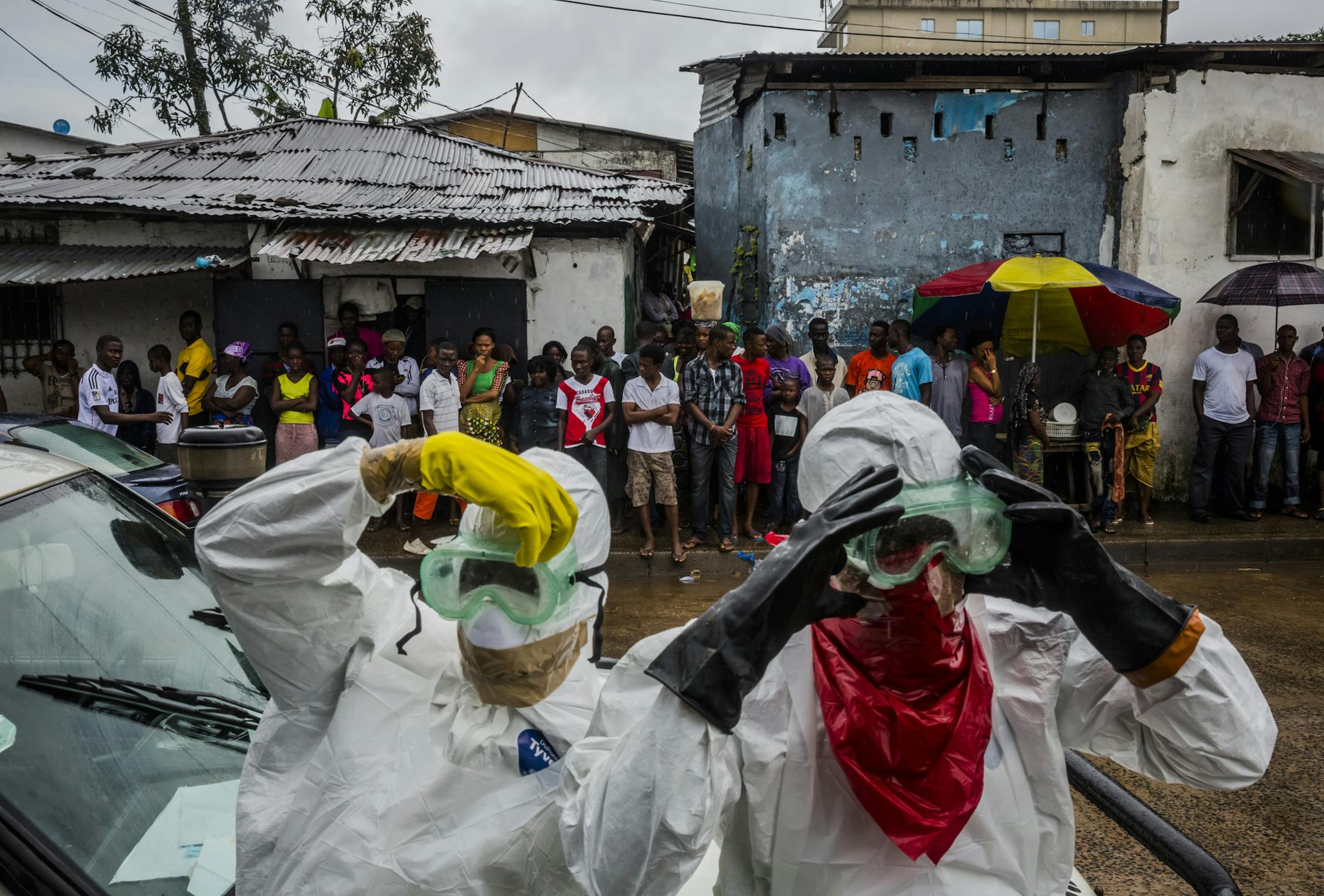A burial team, one of six crisscrossing Monrovia, prepare to remove the body of Lorpu David, 30, in Monrovia, Liberia, Sept. 18, 2014. ‚ÄúWe came here for the husband last week, we‚Äôre back today for the wife, and maybe next week we‚Äôll be back for the children,‚Äù said one body collector, Alexander Nyanti. With the severe shortage of treatment centers, many apparent Ebola patients are dying at home, often infecting family mem