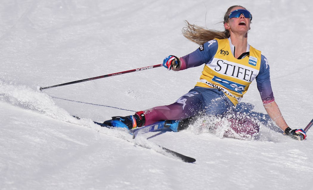 Jessie Diggins collapses to the snow at the end of the women's 10k, finishing third. 