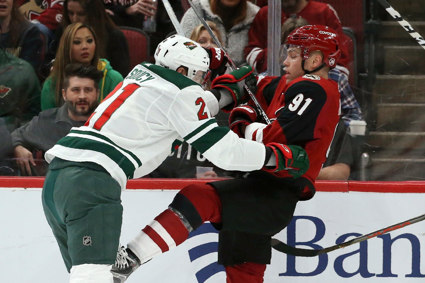 Arizona Coyotes left wing Taylor Hall (91) gets shoved by Minnesota Wild defenseman Carson Soucy, left, during the first period of an NHL hockey game Thursday, Dec. 19, 2019, in Glendale, Ariz. (AP Photo/Ross D. Franklin)