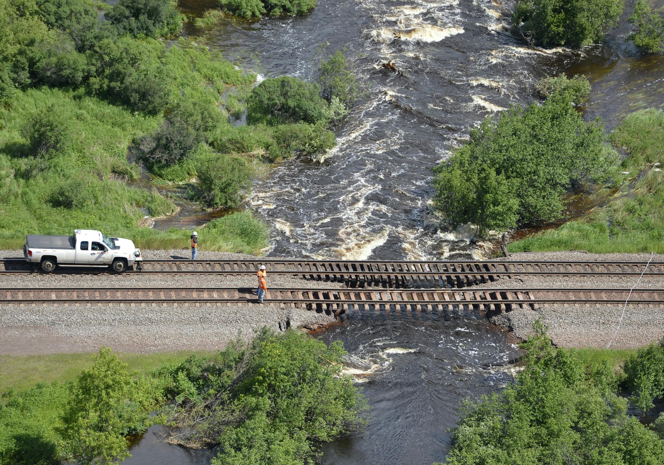 Railroad crews inspect the damage to a section of track west of Duluth