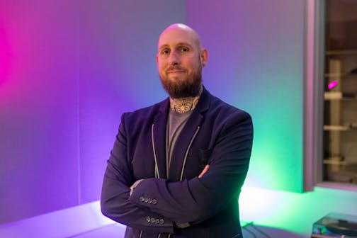 photo of man in front of purple/green background