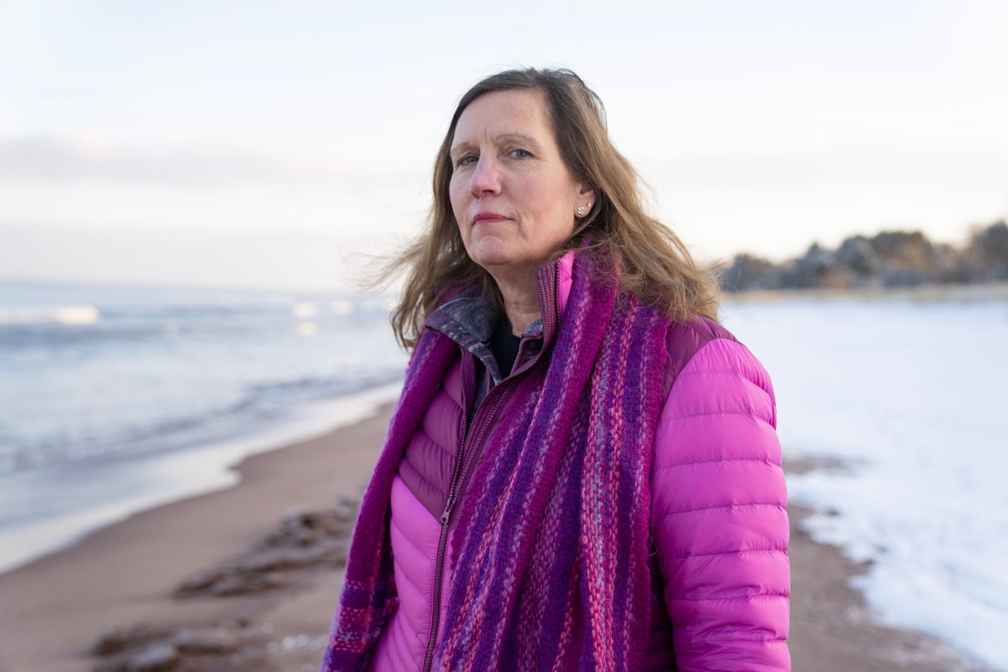 Dawn Buck, president of Park Point Community Club, poses for a portrait Thursday, Jan. 11, 2024, on the shore of Lake Superior at Park Point in Duluth, Minn. Buck is deeply concerned that a member of the Cargill family has bought 10 homes on the long sandbar. She hopes to work with Kathy Cargill to get her involved in the community. ]