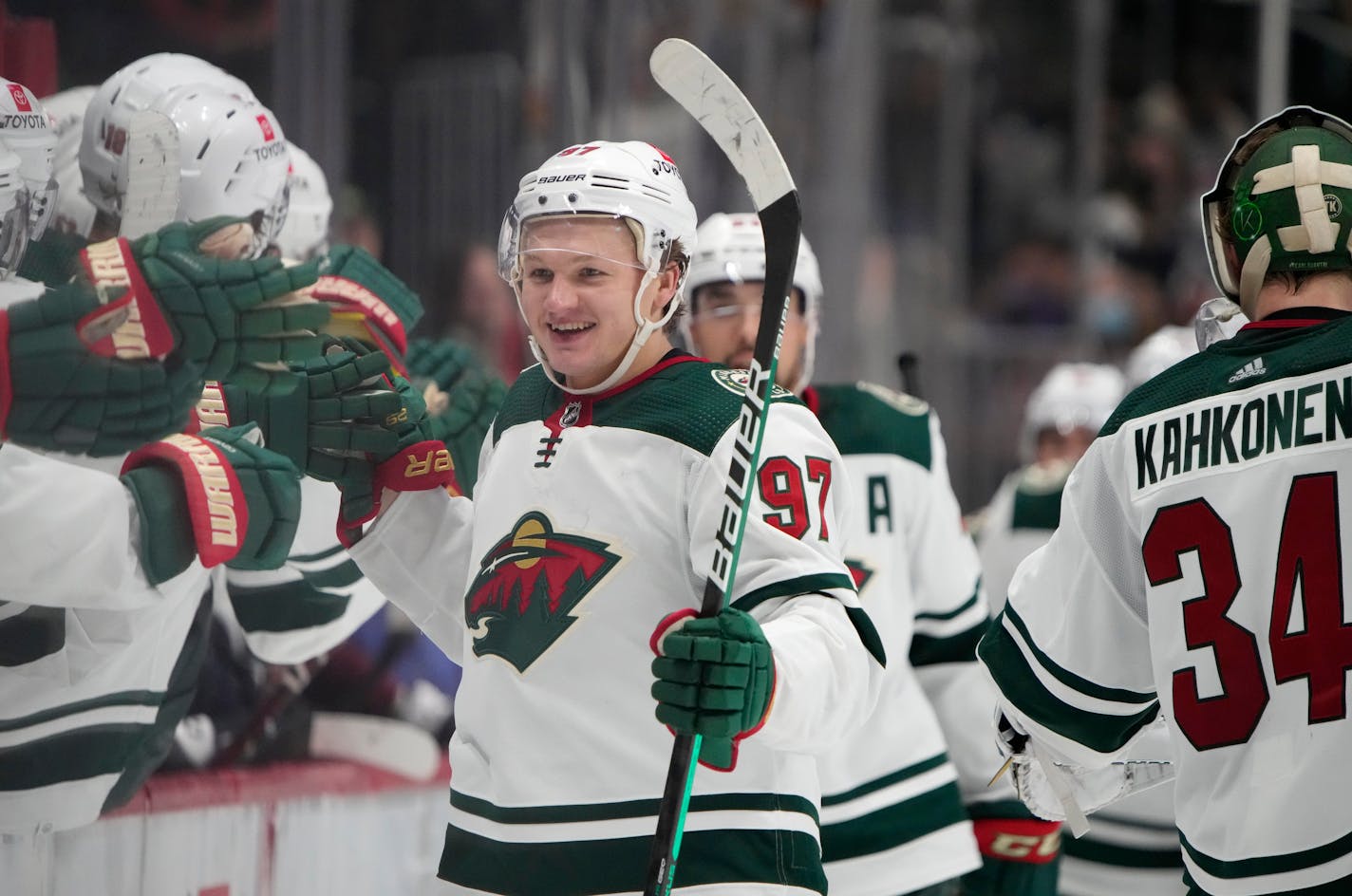 Minnesota Wild left wing Kirill Kaprizov is congratulated as he passes the team box after scoring a goal in the third period of an NHL hockey game against the Colorado Avalanche, Monday, Jan. 17, 2022, in Denver. (AP Photo/David Zalubowski)