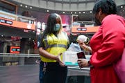 MTA employee Shanita Hancle, left, hands out masks to commuters at the entrance to a subway station in New York, Thursday, June 8, 2023. Air pollution