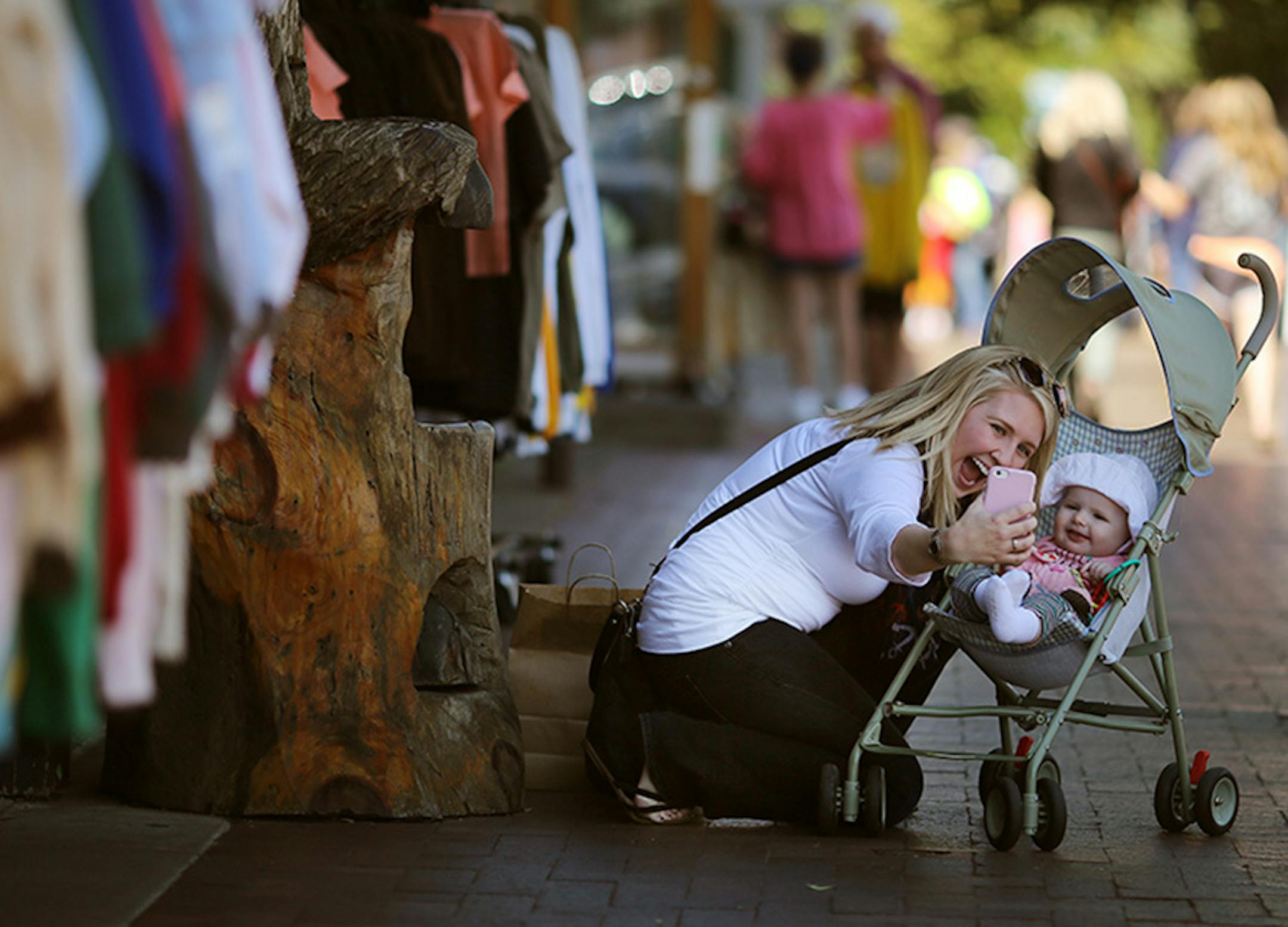 Christina Nelson of Barnum, MN took a photo with her 9-month old daughter Olivia Nelson as she shopped on Canal Park Wednesday August 27 2015 in Duluth, MN. A profile on the resurgence of Duluth.