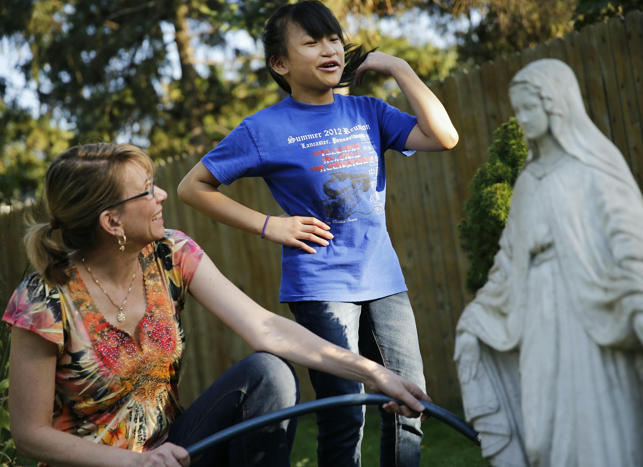 At their home in Roseville, devout catholics Karin Freihammer and daughter Junfen,12, played with Daisy and did some yard work.JunFen Freihammer had adult medical devices adapted to help straighten her spine. She went from a 108 degree bend to 30 degree bend after several operations .]richard tsong-taatarii/rtsong-taataarii@startribune.com ORG XMIT: MIN1309261838103929