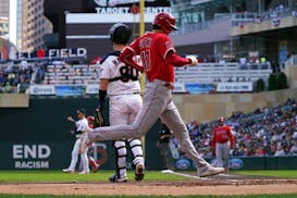 Shohei Ohtani scores on a single by Matt Thaiss in the first inning Sunday at Target Field