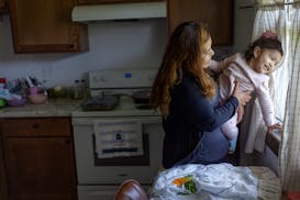 Yanet Santos Gómez juega con su hija menor, Yareli Rocío, de casi dos años de edad, en su departamento en Ridgeway, Iowa, donde trabaja en una lech