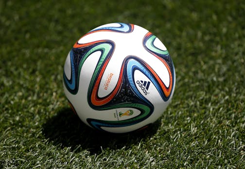 An official 2014 FIFA World Cup soccer ball lays on the grass during an open practice by the United States.