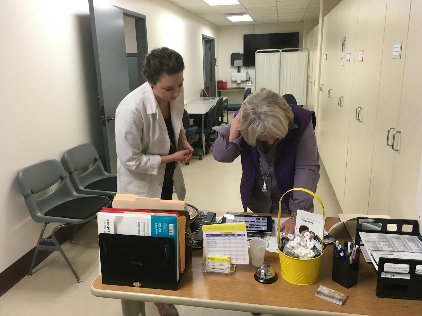 Nurse practitioner Nicole Leand (left) and Becky Fink, executive director of Nucleus Clinic, work the check-in table between appointments Tuesday at a newly opened health clinic on the Coon Rapids campus of Anoka-Ramsey Community College.