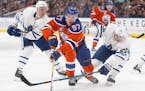 Toronto Maple Leafs' Leo Komarov (47) and Nikita Zaitsev (22) try to stop Edmonton Oilers' Connor McDavid (97) during second period NHL hockey action 