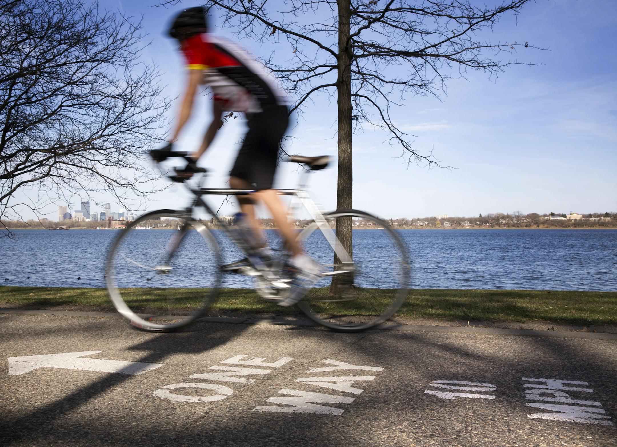 A bicyclist rides along the bike path around Lake Calhoun in Minneapolis on Wednesday, April 15, 2015. ] LEILA NAVIDI leila.navidi@startribune.com / BACKGROUND INFORMATION: City park officials are debating doing away with the bicycle speed limit of 10 mph, saying they are not enforceable.