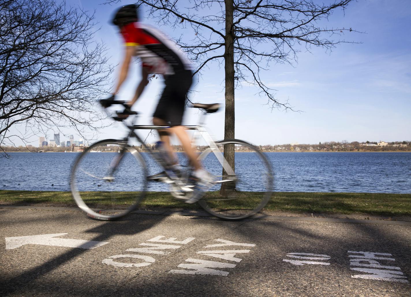 A bicyclist rides along the bike path around Lake Calhoun in Minneapolis on Wednesday, April 15, 2015. ] LEILA NAVIDI leila.navidi@startribune.com / BACKGROUND INFORMATION: City park officials are debating doing away with the bicycle speed limit of 10 mph, saying they are not enforceable.