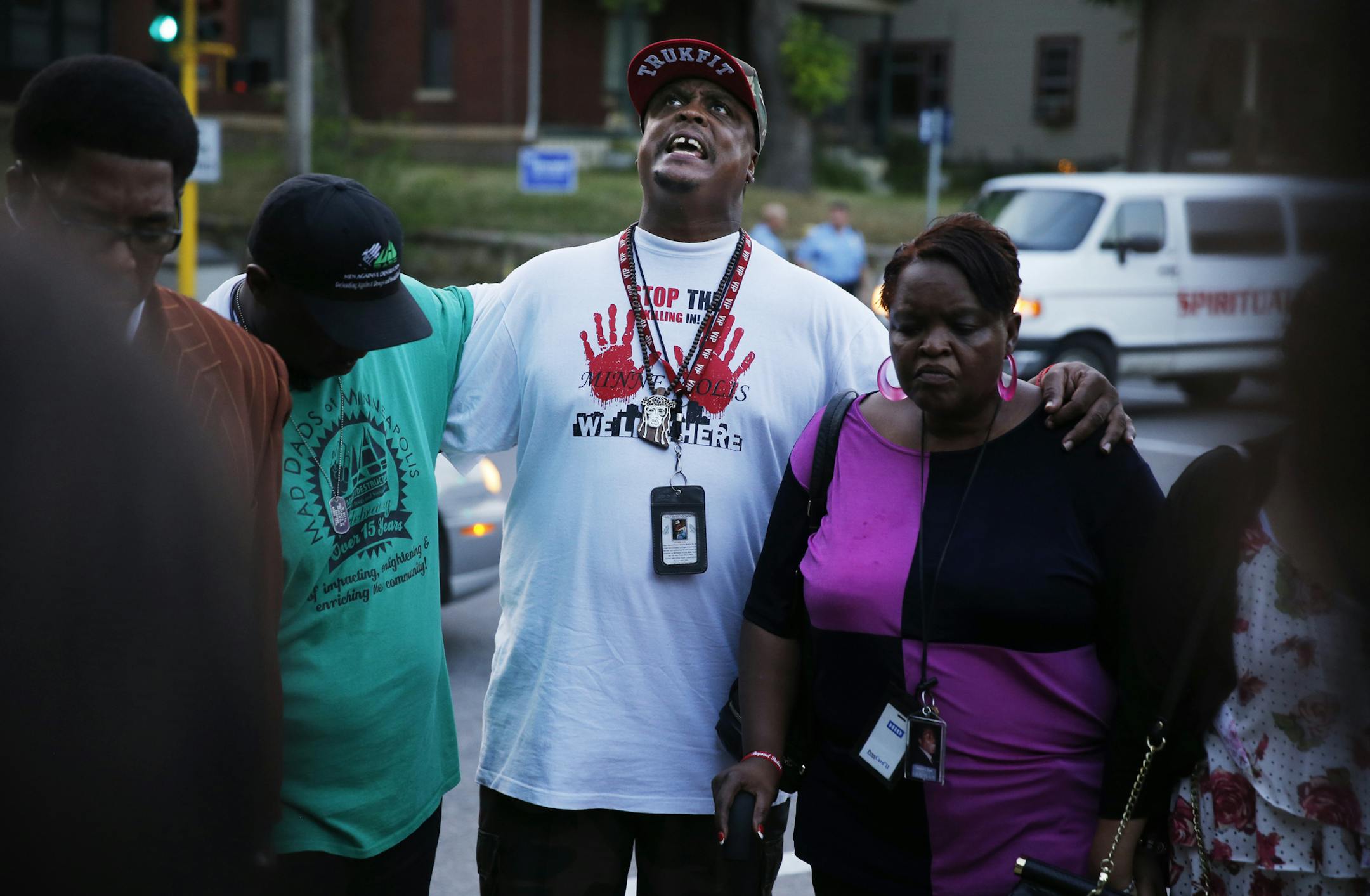 On Lyndale Ave North between 29th and 30th, police investigated the area where three people were shot in the early evening hours. North side activist K.G. Wilson helped lead a prayer for the victims.]tsong-taataarii@startribune.com