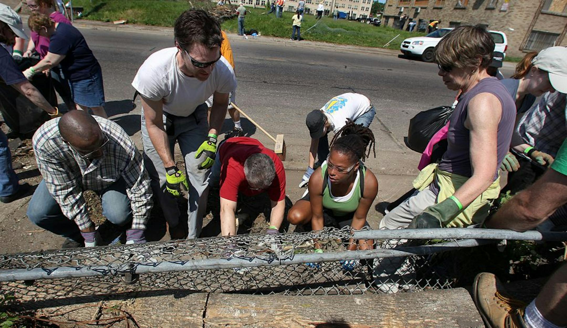 Volunteers tried to lift a fence in order to get at some debris in the area near N. Penn Ave. and N 26th Ave., an area that was heavily damaged by the tornado.