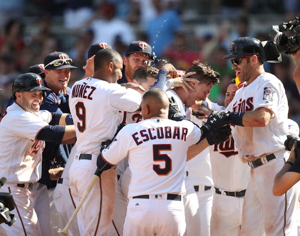 The Twins' Max Kepler mobbed by teammates after his three-run homer won the game in the 10th inning Sunday afternoon.