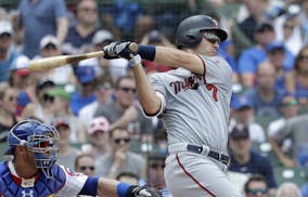 Minnesota Twins' Joe Mauer hits a three-run double off Chicago Cubs starting pitcher Tyler Chatwood during the second inning of a baseball game Saturd