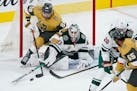 Minnesota Wild goaltender Cam Talbot (33) knocks the puck away from Vegas Golden Knights left wing William Carrier (28) during the third period of an 
