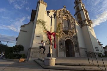 In this Friday, April 10, 2020 photo, Miles de Rouin, 20, an art student at San Francisco State, jumps on his skateboard outside the closed Saint Char