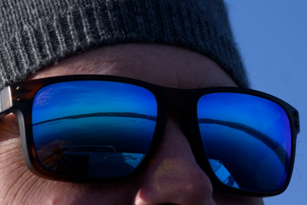 Chris O Brien, communications and marketing coordinator with the Freshwater Society, looks out while approaching an iced-in area Monday, March 11, 2024 on Lake Minnetonka. 